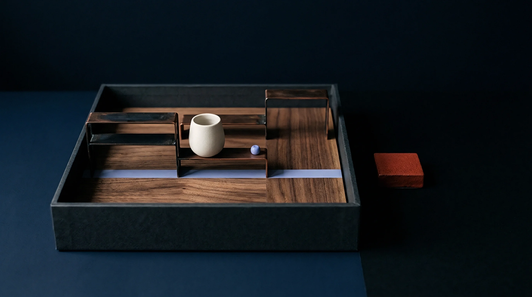A scale prototype model features modular wooden panels, metal risers, and ceramic elements arranged inside a testing tray.