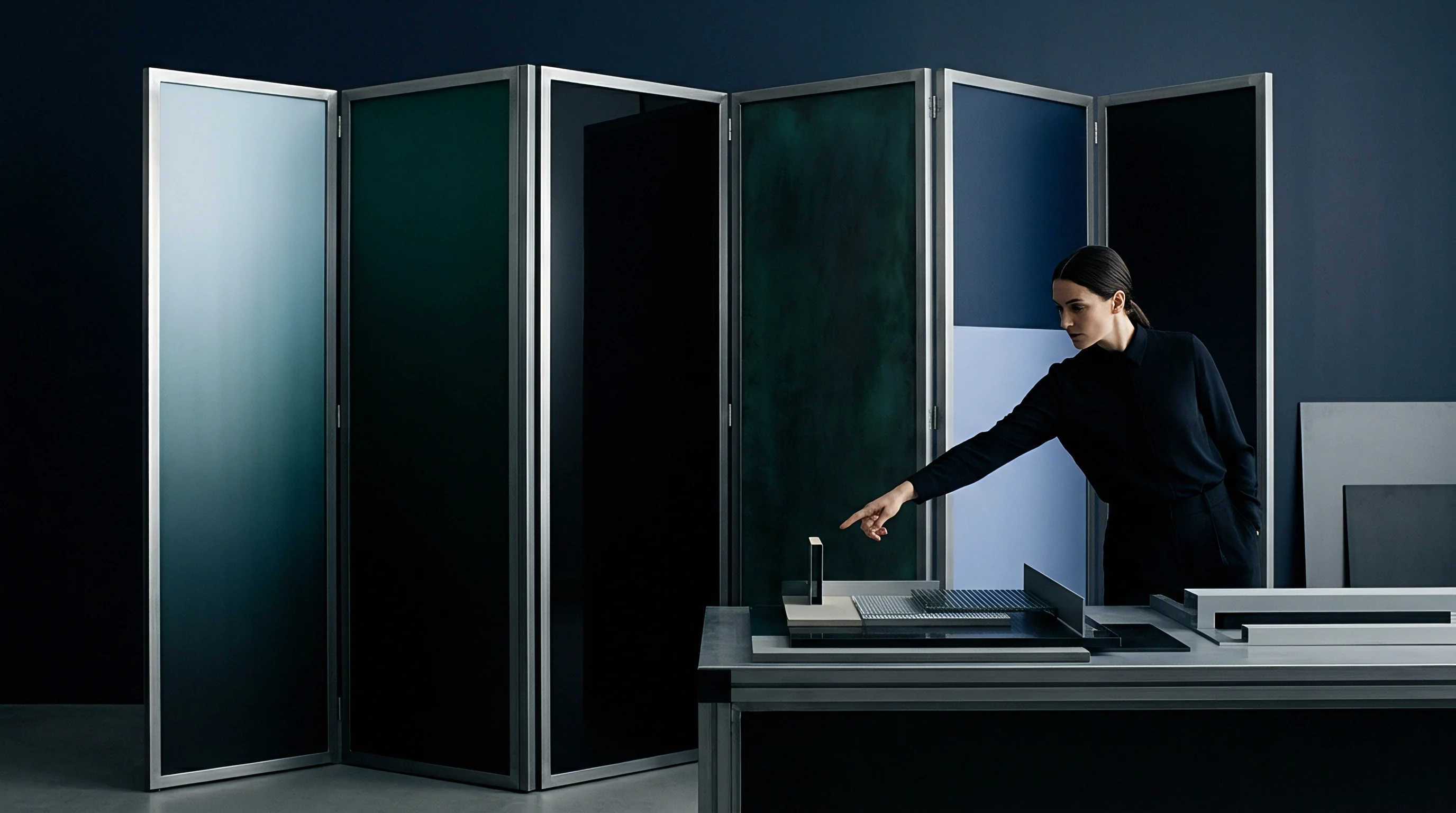 A procurement specialist examines architectural finishes and material samples on a display table inside a manufacturing supplier showroom containing modular panels.